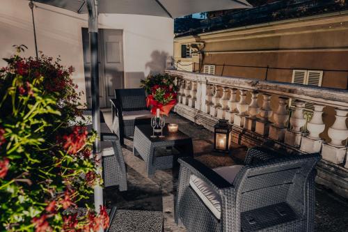 a balcony with chairs and a table with flowers at L'Altana City House in Brescia