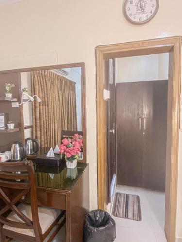 a room with a desk and a mirror and a clock at World Inn by WI Hotel in Karachi