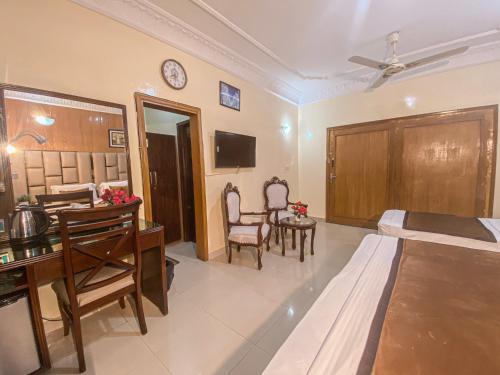 a hotel room with a bed and a desk and a bedroom at World Inn by WI Hotel in Karachi