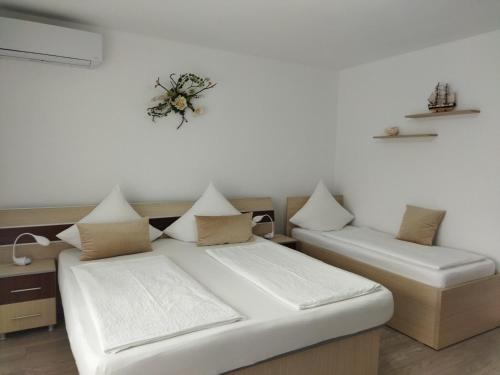 a bedroom with two beds and a wreath on the wall at Vila Marius 2 Mai in 2 Mai
