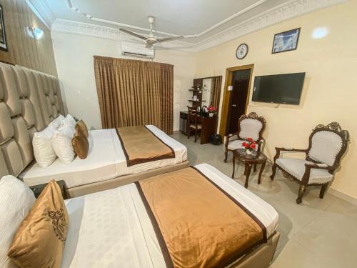 a hotel room with two beds and a television at World Inn by WI Hotel in Karachi