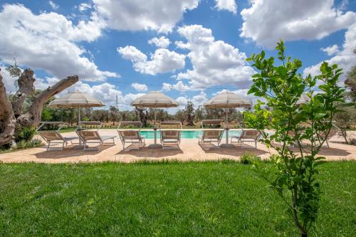 a group of chairs and umbrellas next to a pool at Le Chiese Azienda Bio Agri Turistica in San Pietro in Lama