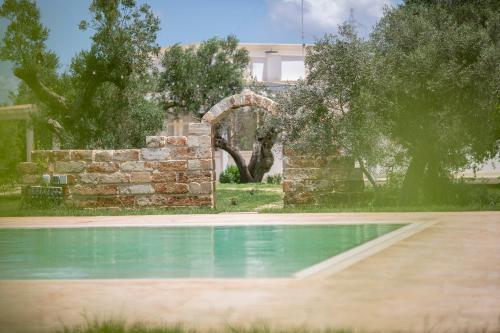a swimming pool in front of a building with trees at Le Chiese Azienda Bio Agri Turistica in San Pietro in Lama