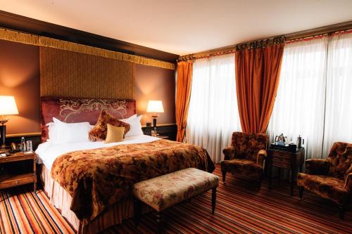 a hotel room with a bed and two chairs at The Merchant Hotel in Belfast