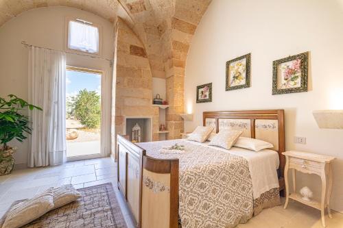 a bedroom with a bed and a large window at Le Chiese Azienda Bio Agri Turistica in San Pietro in Lama