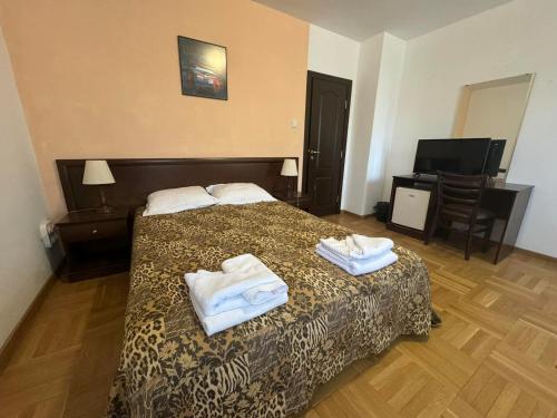 a hotel room with a bed with towels on it at Villa Rila Borovets with Hot Pool, Jacuzzi & Sauna by BookVillaBG in Borovets