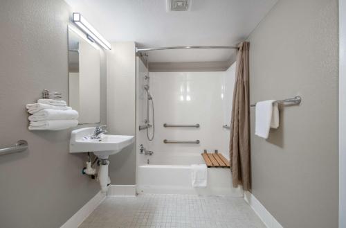 a white bathroom with a shower and a sink at Motel 6-Lompoc, CA in Lompoc