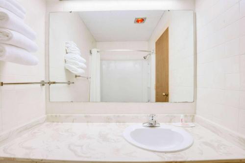 a white bathroom with a sink and a mirror at Super 8 by Wyndham Port Clinton in Port Clinton