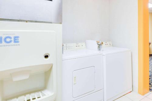 a white laundry room with a washer and dryer at Super 8 by Wyndham Port Clinton in Port Clinton