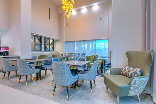 a dining room with tables and chairs and a fireplace at Hampton Inn & Suites by Hilton Shenandoah The Woodlands in The Woodlands