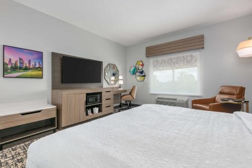 a hotel room with a bed and a flat screen tv at Hampton Inn & Suites by Hilton Shenandoah The Woodlands in The Woodlands