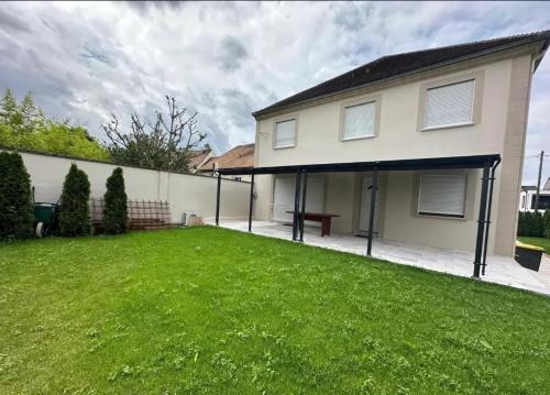a house with a large lawn in front of it at Maison spacieuse avec terrasse à Pontault-Combault in Pontault-Combault