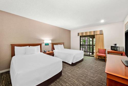 a hotel room with two beds and a desk at Best Western Stagecoach Inn in Pollock Pines