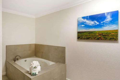 a bathroom with a bath tub and a painting on the wall at Best Western Heritage Inn in Bakersfield