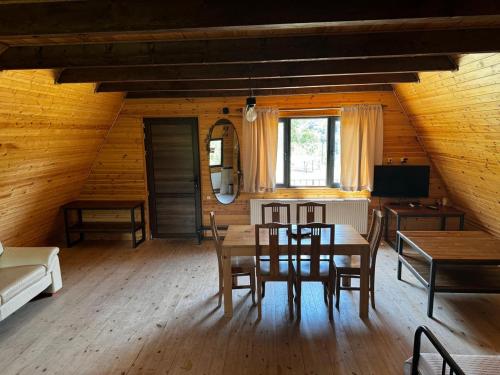 a dining room with a table and chairs in a room at Borjomi Cottage Sadgeri in Sadgeri