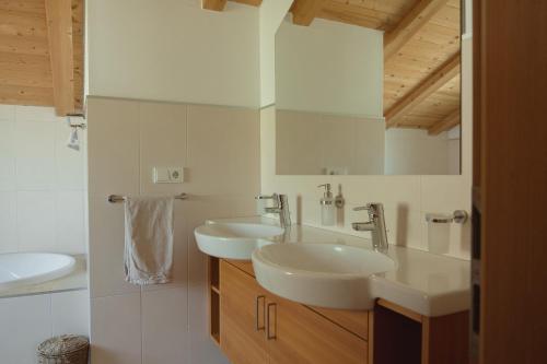 a white bathroom with two sinks and a mirror at 164 apt. in Val di Vizze