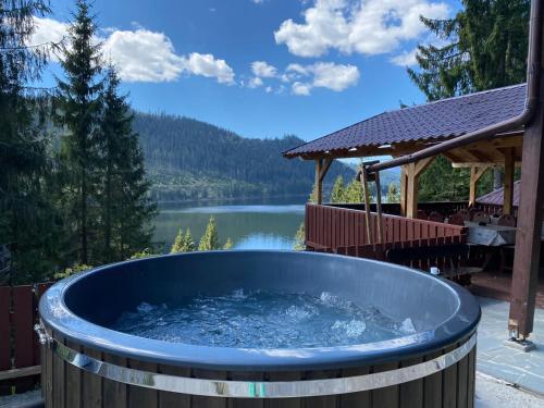 a hot tub with a view of a lake at Perla Lacului in Rişca