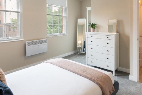 a bedroom with a bed and a dresser and windows at Host & Stay - The Quarter in Liverpool
