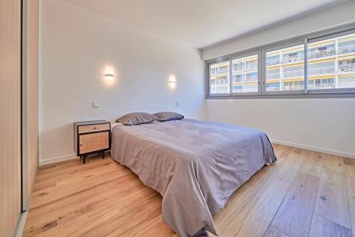 une chambre avec un grand lit et une fenêtre dans l'établissement Spacieux T3 en front de mer, à Sainte-Maxime