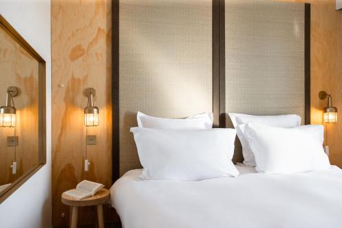 a bedroom with a white bed with white pillows at MOB HOTEL Cannes in Cannes