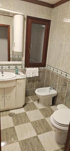 a bathroom with a sink and a toilet and a mirror at Casa da Mila in Rio Caldo