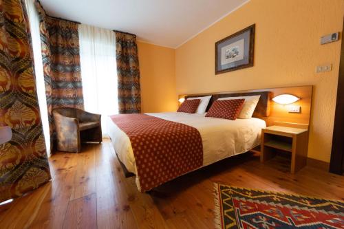 a hotel room with a bed and a chair at Hotel Bouton d'Or - Courmayeur in Courmayeur