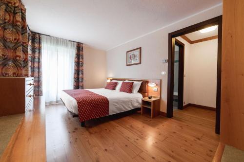 a hotel room with a bed and a window at Hotel Bouton d'Or - Courmayeur in Courmayeur
