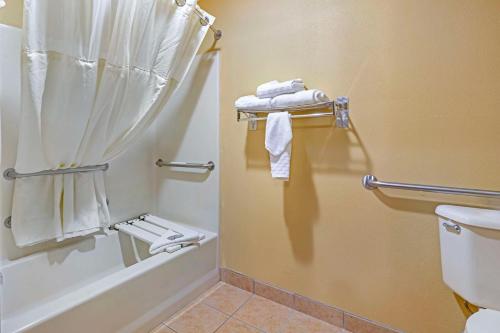a bathroom with a shower and a toilet and towels at Best Western Cascade Inn & Suites in Troutdale