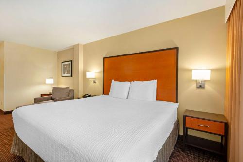 a hotel room with a large bed and a chair at Best Western Cascade Inn & Suites in Troutdale