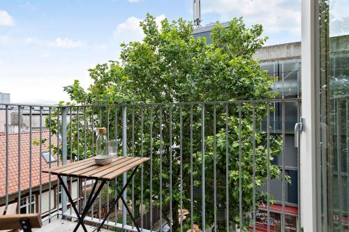 a balcony with a table and a tree on a building at Beautiful City Center Apartment w Balcony in Aarhus