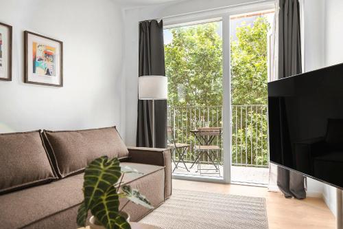 a living room with a couch and a sliding glass door at Beautiful City Center Apartment w Balcony in Aarhus
