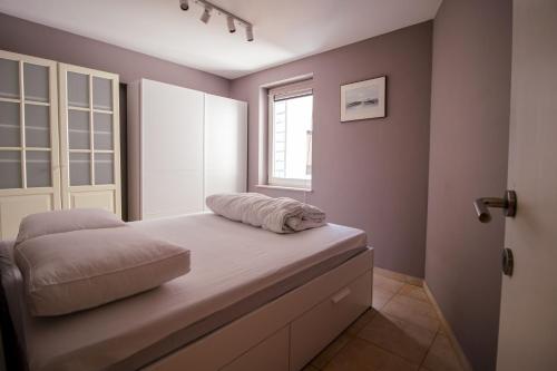 una cama en una habitación con ventana en Walter R-082, en Koksijde