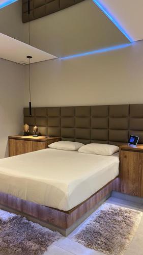 a bedroom with a large bed with a blue light at Status Motel Ourinhos in Ourinhos