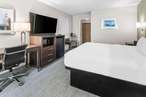 a hotel room with a bed and a desk and a tv at Best Western Abilene Inn & Suites in Abilene
