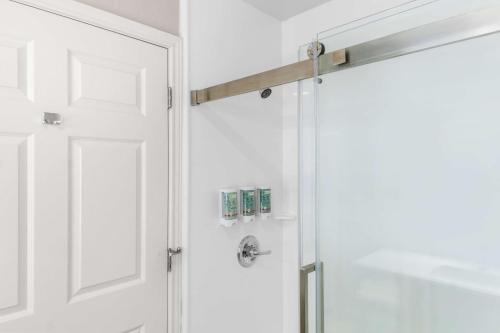 a bathroom with a shower with a white door at Best Western Abilene Inn & Suites in Abilene
