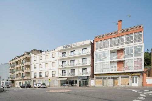 a white building on the corner of a street at Hotel Alda Vía Norte in O Grove