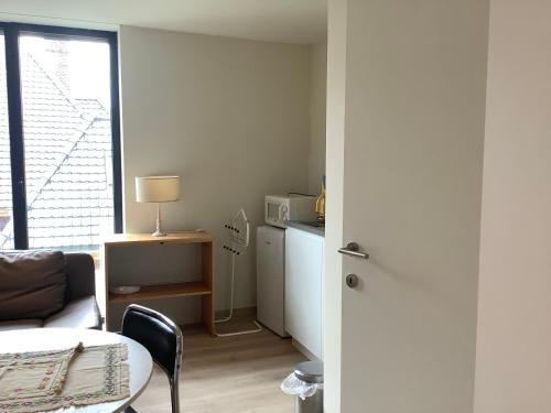 シント・マルテンス・ラーテムにあるPoppy Home Gent Homestayのソファとテーブルと窓のあるリビングルーム
