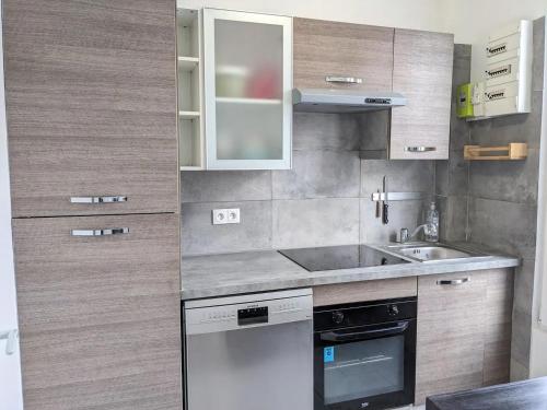 Il comprend une petite cuisine équipée d'un évier et d'un lave-vaisselle. dans l'établissement Maison rénovée avec jardinet près Paris 5 minutes du métro, à Montreuil