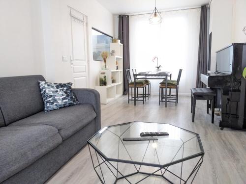 un salon avec un canapé et une table basse en verre dans l'établissement Maison rénovée avec jardinet près Paris 5 minutes du métro, à Montreuil