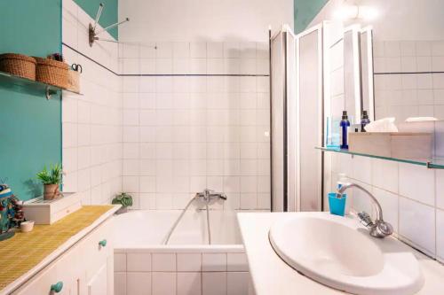 une salle de bain blanche avec une baignoire et un lavabo dans l'établissement Vintage 2BD Apartment with Patio in Montmartre, à Paris