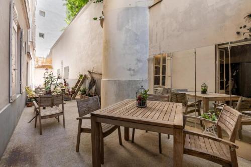 un patio avec une table et des chaises en bois dans l'établissement Vintage 2BD Apartment with Patio in Montmartre, à Paris