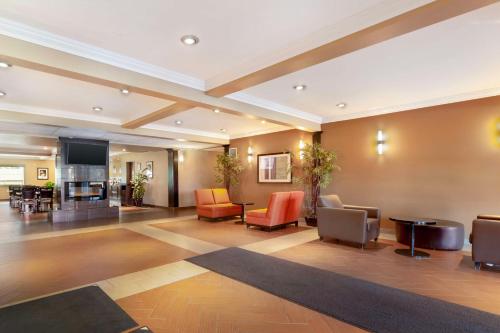 a lobby of a hotel with chairs and a table at Best Western Plus Peace River Hotel & Suites in Peace River