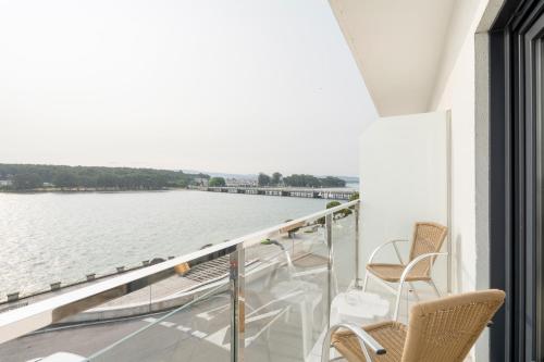 a balcony with chairs and a view of the water at Hotel Alda Vía Norte in O Grove