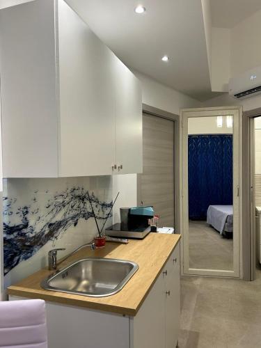 a kitchen with a sink and a room with a bed at CASA DI ANGELA 2.0 in Sciacca
