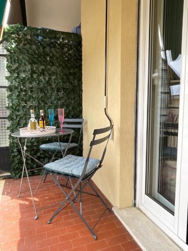 una sedia seduta su un patio con un tavolo con bicchieri di Vista Mare a 150 mt dalla spiaggia - free parking e AC a Pietra Ligure