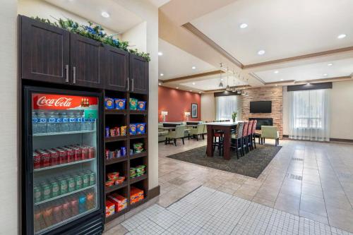 a coca cola refrigerator in a cafeteria with a table at Best Western Pacific Inn in Vernon