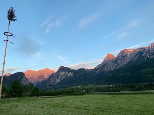 a field with a view of a mountain range at Wengerwirt zur Laube Komfortzimmer Deluxe in Weng im Gesäuse