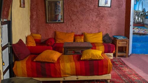 a living room with a couch with colorful pillows at Gîte Forest Tagroumte in Azrou