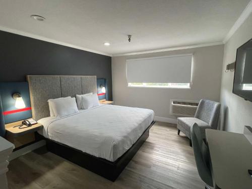 a hotel room with a bed and a chair at The Midtowner Hotel, SureStay Collection by Best Western in Sacramento