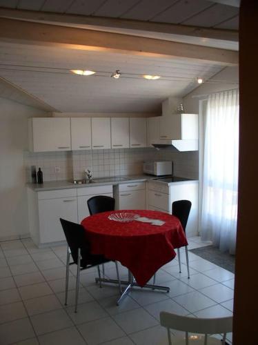 a kitchen with a table with a red table cloth on it at 110 m2 Wohnung mit Terrasse in Cheyres VIVARTE Feriencheyres in Cheyres